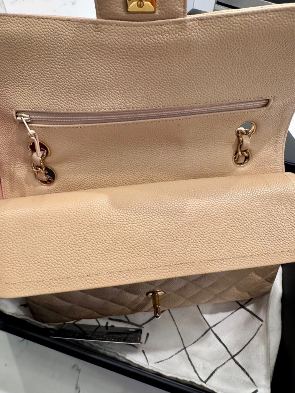 Chanel Classic Medium Double Flap in beige nude caviar with gold tone hardware.